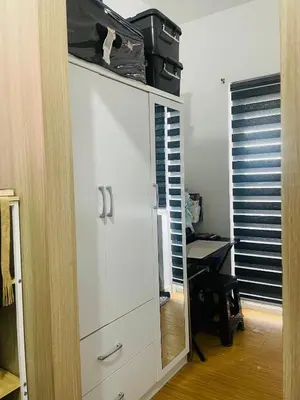 a white cabinet in a room with a desk at SMDC Grace Residences in Manila