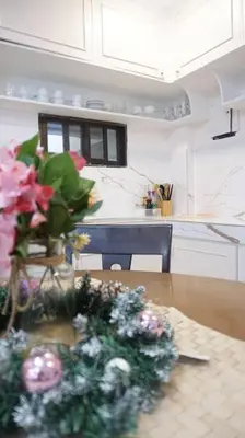 a kitchen with a table with a vase of flowers on it at 4-5br Apartment in Paranaque for Staycation in Manila