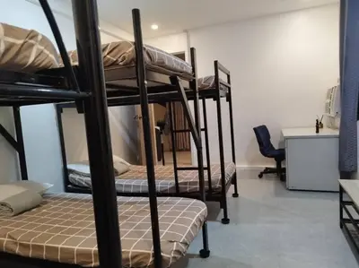 a room with three bunk beds with a desk at 4-5br Apartment in Paranaque for Staycation in Manila