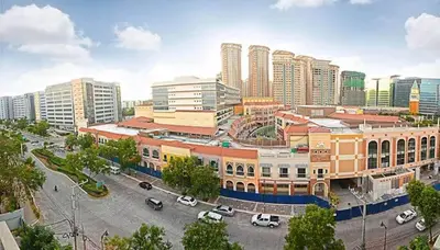 a city with cars parked in a parking lot at Bell Place at Venice Luxury Mckinley Hill in Manila