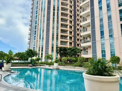 a swimming pool in front of a tall building at Bell Place at Venice Luxury Mckinley Hill in Manila
