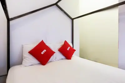 a bedroom with red pillows on a white bed at Spot On Junction Hostel in Manila