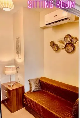 a bedroom with a bed and a sitting room at Rys Sheridan Tower Mandaluyong in Manila