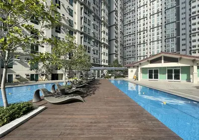a swimming pool with benches next to tall buildings at Cozy 2BR 2Bath San Lorenzo Place Netflix 4KM NAIA in Manila