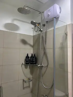 a bathroom with a shower with a blow dryer at E & R Staycation Condotel near Mall of Asia in Manila