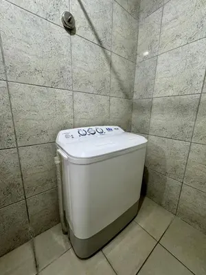 a toilet in a bathroom with a tiled wall at AMA Tower Studio, 8th flr, near DMW and SM Megamall in Manila