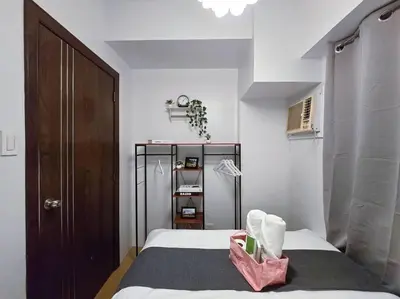 a bedroom with a bed with a pink bag on it at 1BR Condotel Ridgewood Towers Taguig City #RW02 in Manila