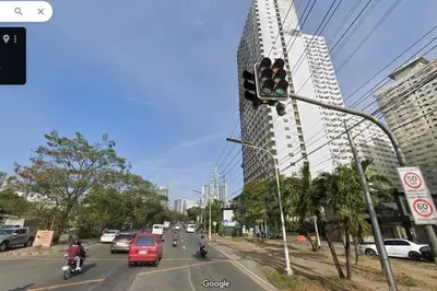 a traffic light on a city street with cars and motorcycles at 1BR Condotel Ridgewood Towers Taguig City #RW02 in Manila