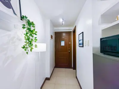 a hallway with a door and a plant on the wall at 1BR Condotel Ridgewood Towers Taguig City #RW03 in Manila