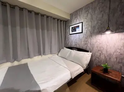 a bedroom with a white bed and a window at 1BR Condotel Ridgewood Towers Taguig City #RW11 in Manila