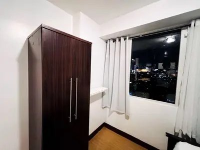 a dark wooden cabinet in a room with a window at 1BR Condotel Ridgewood Towers Taguig City #RW12 in Manila