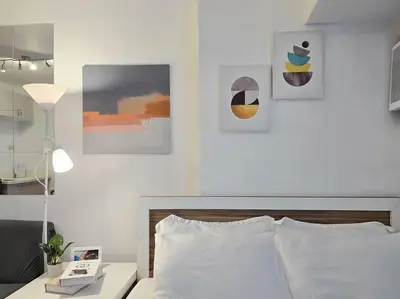 a bedroom with a bed and some pictures on the wall at 1BR Condotel Ridgewood Towers Taguig City #RW14 in Manila