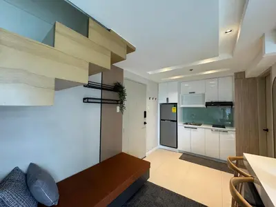 a living room with a staircase and a kitchen at Dazzling fully furnished unit BGC w Pool in Manila