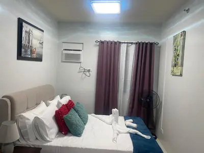 a bedroom with a bed with a unicorn on it at Kral Suite in Las Piñas in Manila