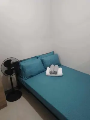 a bedroom with a blue bed with two books at S Residences in Manila