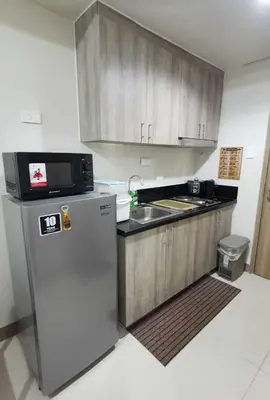 a kitchen with a microwave on top of a refrigerator at S Residences in Manila