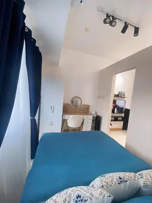 a bedroom with a blue bed and a desk at La Maison d'Antoine in Manila