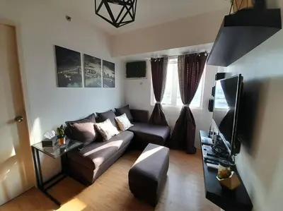 a living room with a couch and a tv at Condo In Manila in Manila