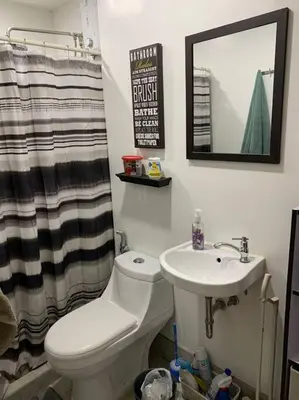 a bathroom with a toilet and a sink and a mirror at Condo In Manila in Manila