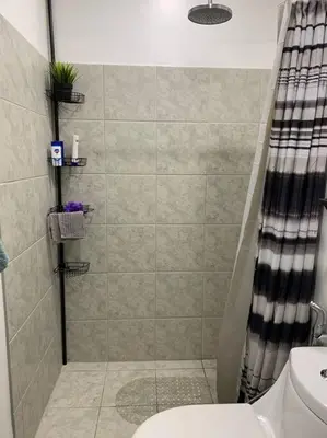 a bathroom with a shower with a toilet and a sink at Condo In Manila in Manila