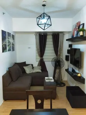 a living room with a couch and a tv at Condo In Manila in Manila
