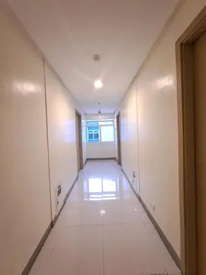an empty hallway in an office building with a window at Grace Tower 3 in Manila
