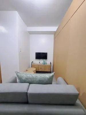 a living room with a couch and a television at Grace Tower 3 in Manila