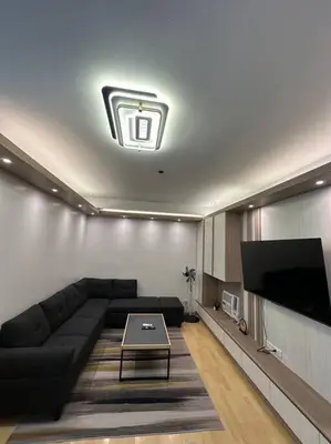 a living room with a couch and a flat screen tv at Spacious 2-bedroom Corner Unit across Shangri-La in Manila