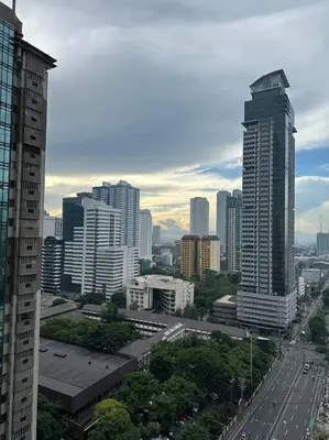 a city skyline with tall buildings and a street at Spacious 2-bedroom Corner Unit across Shangri-La in Manila