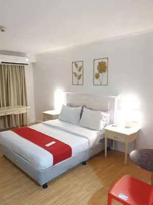 a bedroom with a bed with a red and white blanket at Travel time suites bel air soho in Manila