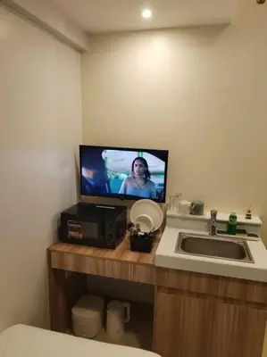 a bathroom with a sink and a tv on a counter at Affordable Studio 2 Twin Beds - City View EDSA in Manila