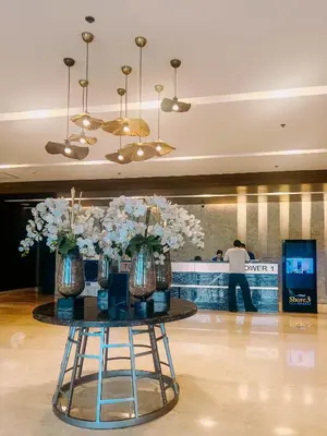 a table with vases of flowers on it in a lobby at Oranje Suite near NAIA AIRPORT in Manila