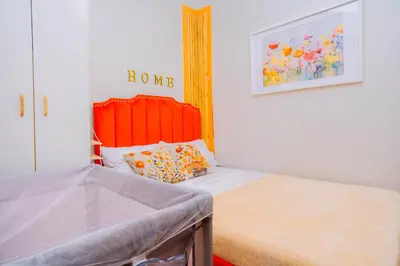 a bedroom with a bed with an orange headboard at Oranje Suite near NAIA AIRPORT in Manila