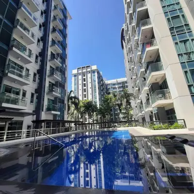 a swimming pool in the middle of two tall buildings at LDN Secret Crib PALM TREE Across NAIA T3 in Manila