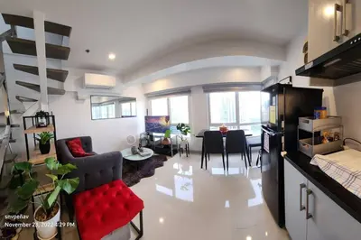 a living room with a red couch and a dining room at Fort Victoria Tower B Condo BGC, Taguig City in Manila
