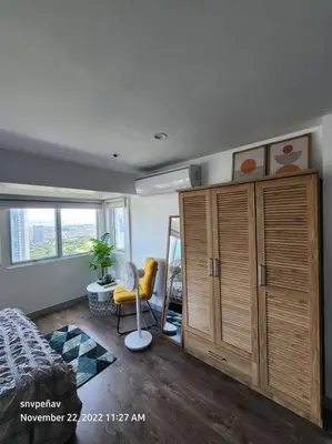 a bedroom with a bed and a cabinet and a window at Fort Victoria Tower B Condo BGC, Taguig City in Manila