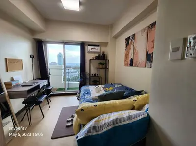 a room with two beds and a desk and a window at Torre de Manila Unit 1720 Taft Avenue Manila Unit 1720 in Manila