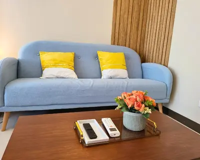a living room with a blue couch and a coffee table at BGC One Uptown Residence King Bed 3 min walk to malls and restaurants in Manila