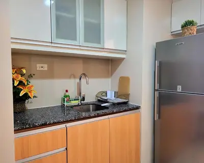 a kitchen with a sink and a refrigerator at BGC One Uptown Residence King Bed 3 min walk to malls and restaurants in Manila
