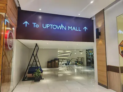 a mall with a sign that reads to uptown mall at BGC One Uptown Residence King Bed 3 min walk to malls and restaurants in Manila