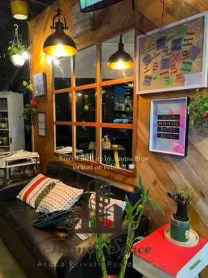 a coffee shop with a leather couch in front of a window at Infinite Space at Acqua Private Residences - Iguazu Tower in Manila