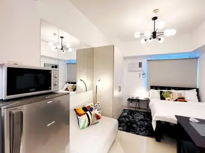 a large white room with a bed and a television at 1BR Condotel with Balcony at SM Light Residences #LT01 in Manila