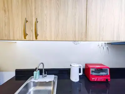 a kitchen counter with a red toaster and a sink at 1BR Condotel with Balcony at SM Light Residences #LT03 in Manila