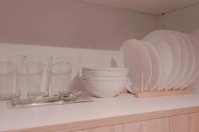 a shelf with plates and bowls and glasses on it at 1BR Condotel with Balcony at SM Light Residences #LT04 in Manila