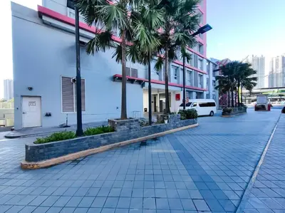 a street with palm trees in front of a building at 1BR Condotel Suite at Sunshine100 City Plaza #SS07 in Manila