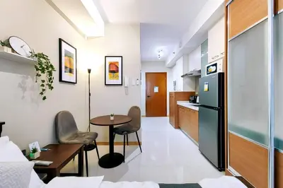 a living room with a table and a kitchen at 1BR Condotel Suite at Sunshine100 City Plaza #SS07 in Manila