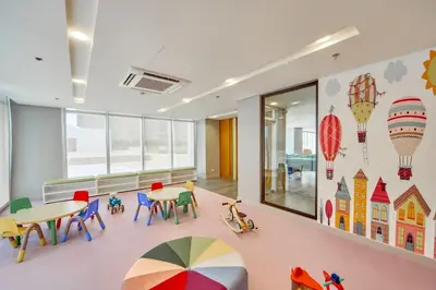 a classroom with tables and chairs and a colorful umbrella at The Connor Serviced Residences Managed by HII in Manila
