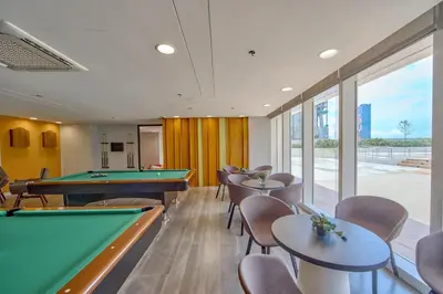a gaming room with pool tables and chairs at The Connor Serviced Residences Managed by HII in Manila