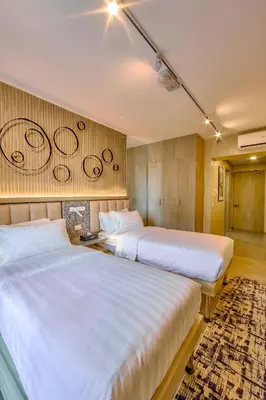 two beds sitting next to each other in a room at The Connor Serviced Residences Managed by HII in Manila