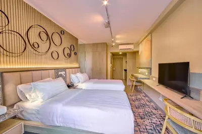 a hotel room with two beds and a flat screen tv at The Connor Serviced Residences Managed by HII in Manila